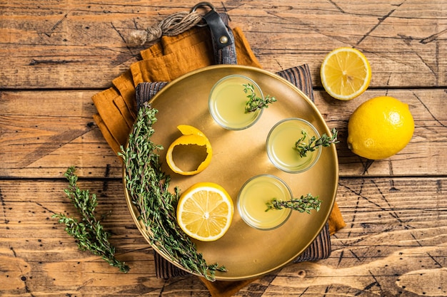 Scatti di limoncello Liquore al limone italiano Sfondo in legno Vista dall'alto