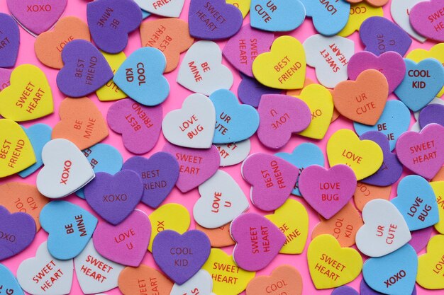Scatto a fotogramma completo di forme di cuore multicolori su uno sfondo rosa