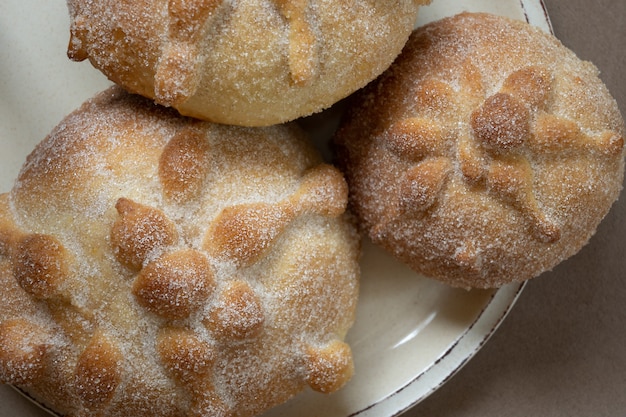 Scatto dall'alto di tre tradizionali pan de muerto, toni beige