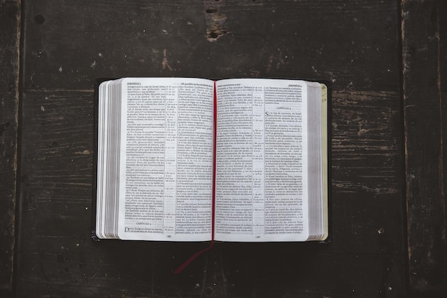 Scatto dall'alto di una Bibbia aperta su una superficie di legno nera