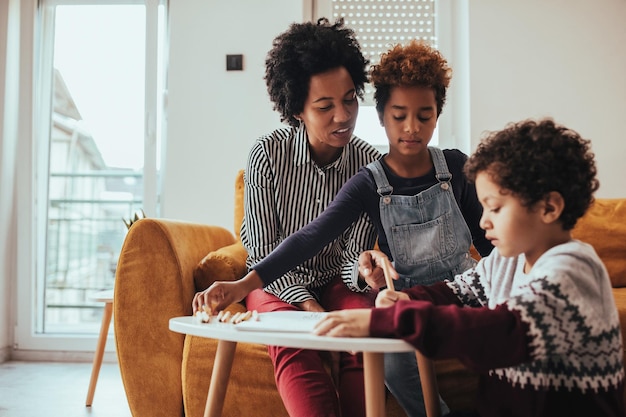 Scatto di due bambini e mamma che dipingono immagini a casa