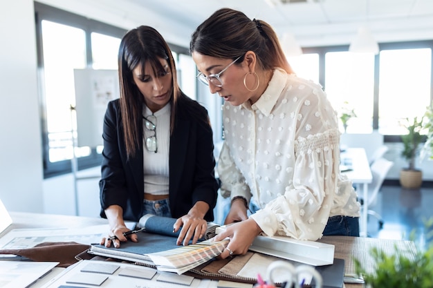 Scatto di due bellissime giovani donne designer che lavorano in un progetto di design mentre scelgono i materiali in ufficio.