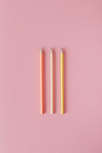 Scatto direttamente sopra di matite multicolori contro uno sfondo rosa