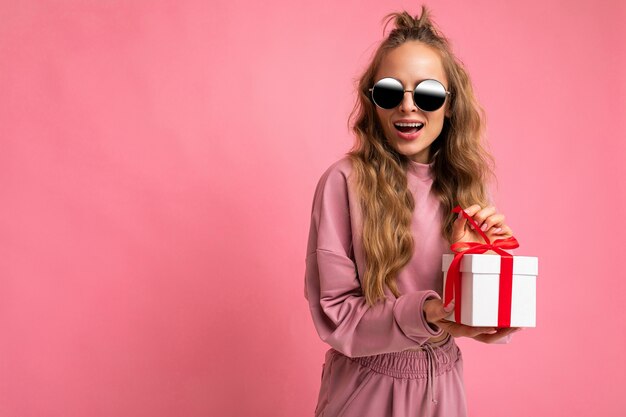 Scatto fotografico di una giovane e bella donna bionda riccia felice positiva e attraente che indossa abiti alla moda