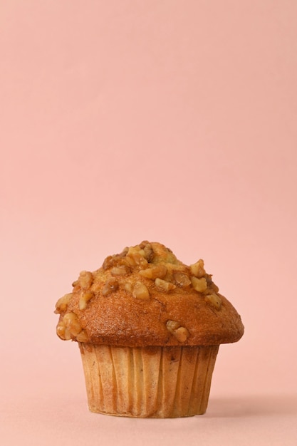 Scatto frontale di cupcake con noci su sfondo rosa pastello