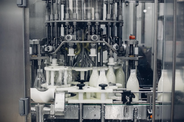 Scatto in scala di grigi di una macchina per l'imbottigliamento del latte in una fabbrica