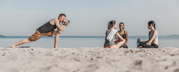 Scatto panoramico del fotografo che scatta foto di gruppo di donne che si riposano dopo il fitness