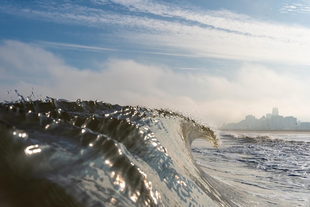 Scatto panoramico delle onde del mare che schizzano sulla riva contro il cielo
