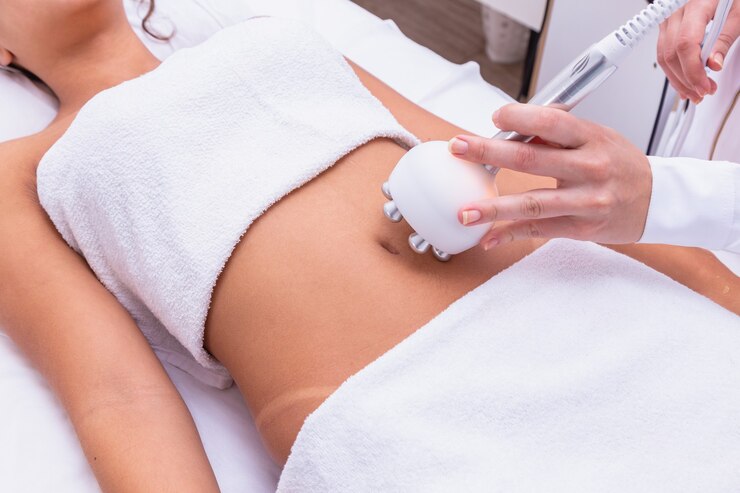 Scatto ritagliato di un dermatologo professionista che esegue una procedura di sollevamento a radiofrequenza sullo stomaco di una donna. Cliente femminile che riceve un trattamento di sollevamento rf sulla pancia presso la clinica di cosmetologia
