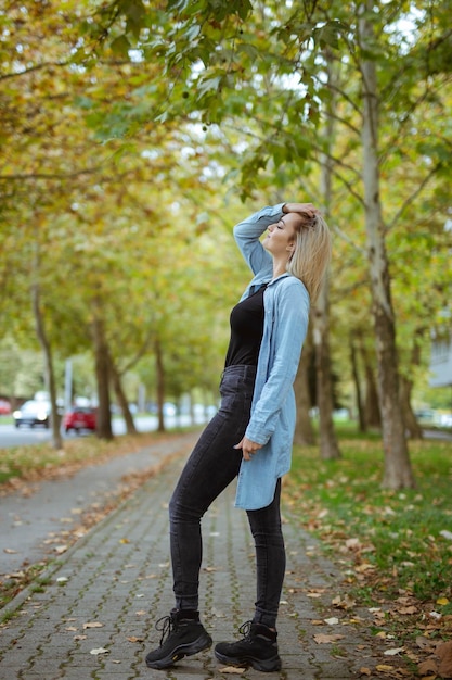 Scatto verticale di una bellissima donna caucasica che posa in un parco