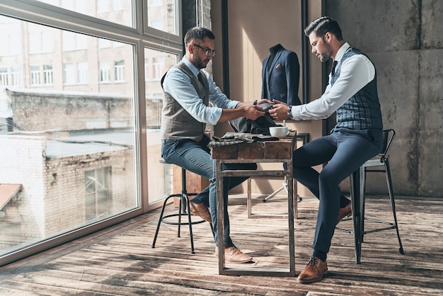 Scelta difficile. Giovane stilista alla moda che sceglie il tessuto con il suo cliente