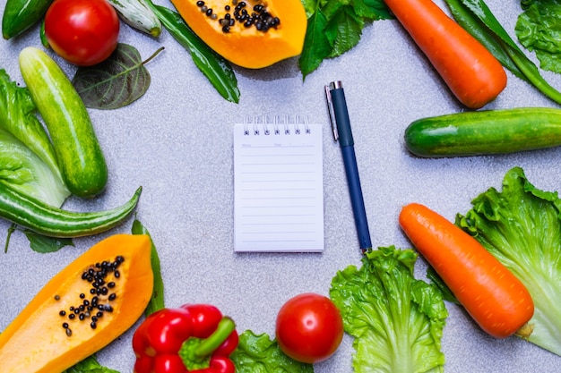 Scelte alimentari sane per mangiare pulito: frutta, verdura, semi, verdure a foglia su cemento grigio