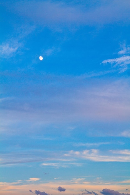Scena del cielo tranquillo verticale con luna e nuvole colorate
