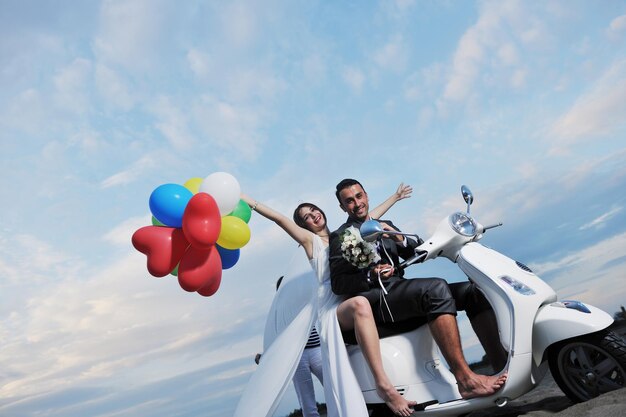 scena del matrimonio degli sposi appena sposati sulla spiaggia, giro in scooter bianco e divertirsi