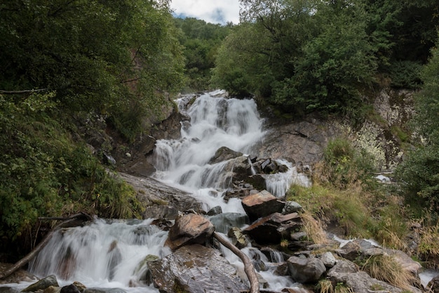 Scena della cascata di vista del primo piano in montagne, parco nazionale di Dombay, Caucaso, Russia. Paesaggio estivo, tempo soleggiato e giornata di sole