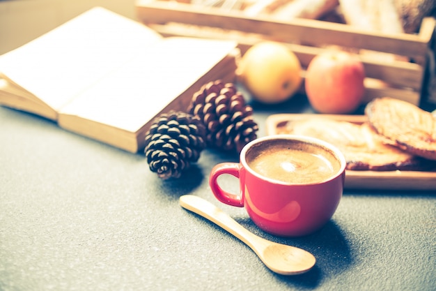 Scena della prima colazione con tazza di caffè, pane e frutta sul tavolo. Tono vintage