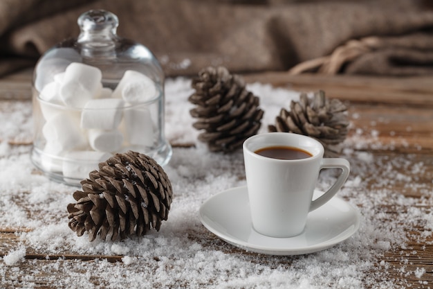 Scena di inverno di vecchia tavola di legno con neve e la tazza