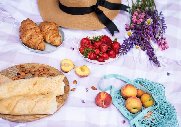 Scena di picnic romantico il giorno d'estate. Picnic all'aperto con vino e frutta all'aperto sullo sfondo dell'erba verde.