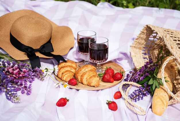 Scena di picnic romantico il giorno d'estate. Picnic all'aperto con vino e frutta all'aperto sullo sfondo dell'erba verde.