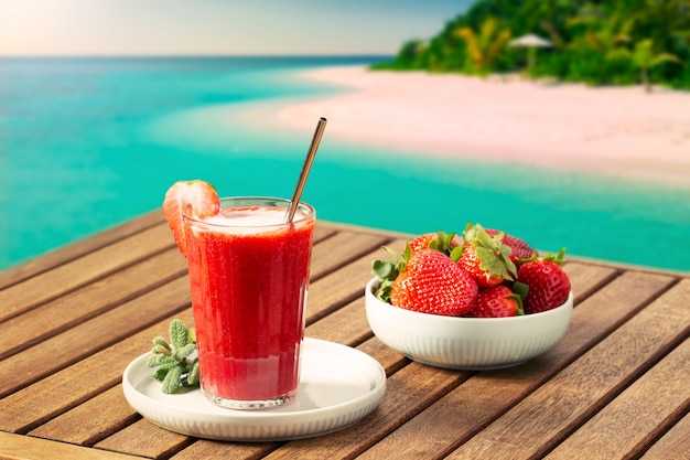 Scena di vacanza con frullato di fragole e spiaggia tropicale