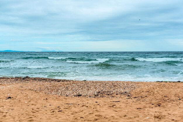 Scena estiva con acqua di mare blu schiuma bianca e sabbia gialla con fuoco selettivo Concetto di vacanza o vacanza Sfondo della natura con spazio per la copia