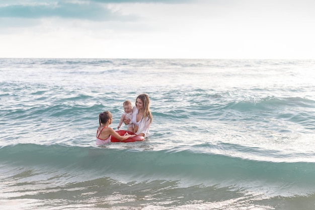 Scena felice sulla costa, bambini con la mamma.