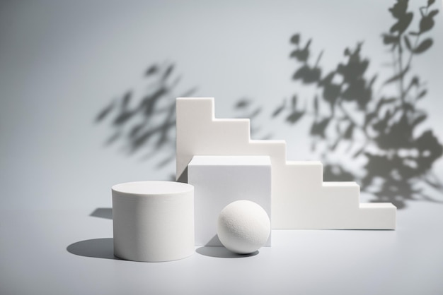 Scena minimalista astratta con podio di forme geometriche su sfondo bianco con ombre prodotto pre