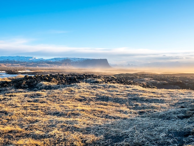 Scena naturale con montagne di campo di nebbia mattutina e cielo blu nuvoloso nella zona rurale dell'Islanda