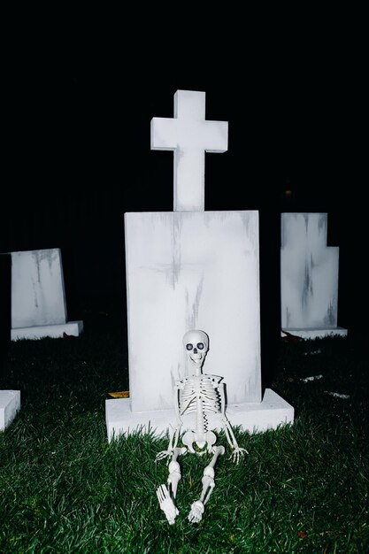 Scena notturna di un cimitero con uno scheletro