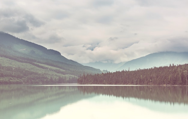 Scena serena dal lago di montagna con il riflesso delle rocce nell'acqua calma.