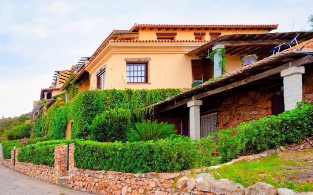 Scenario con casa e rustici a Capo Coda Cavallo, San Teodoro in provincia di Olbia-Tempio, isola della Sardegna, in Italia. Sullo sfondo il Mar Mediterraneo. Isola di Tavola