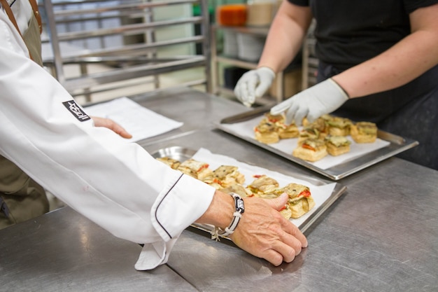 Scene di vero lavoro di squadra di grandi professionisti spagnoli dell'alta cucina gourmet per eventi sociali