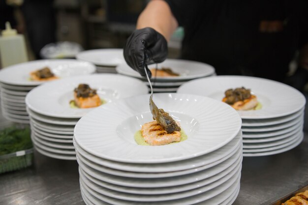 Scene di vero lavoro di squadra di grandi professionisti spagnoli dell'alta cucina gourmet per eventi sociali