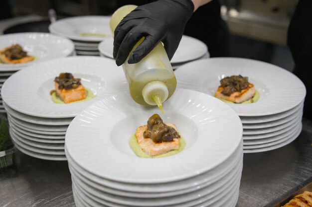 Scene di vero lavoro di squadra di grandi professionisti spagnoli dell'alta cucina gourmet per eventi sociali