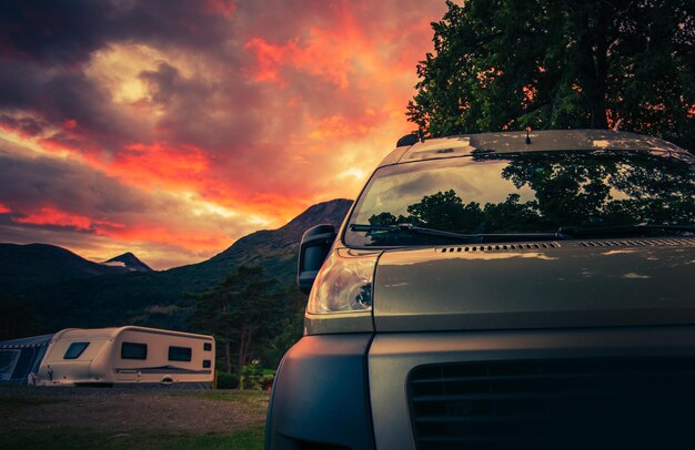 Scenic RV Park Camping durante il bellissimo tramonto estivo Motorhome e Travel Trailers sullo sfondo