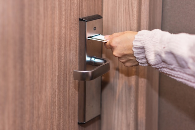 Scheda di inserimento della mano della donna per aprire serratura elettronica nella porta dell&#39;hotel