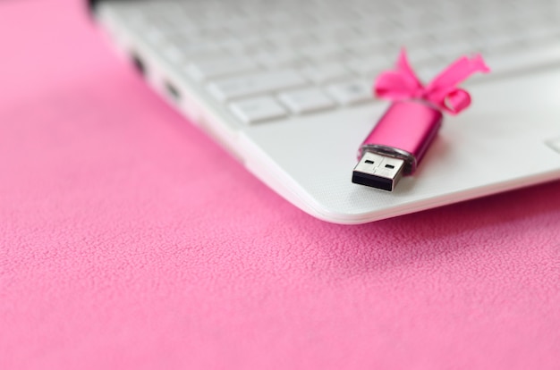 Scheda di memoria flash USB brillante rosa con un fiocco rosa