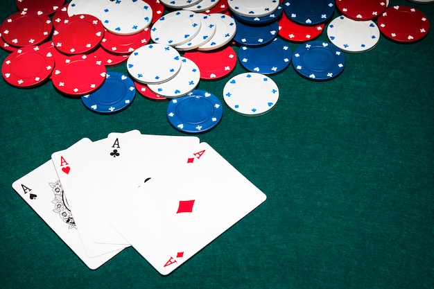 Scheda di tre assi e fiches del casinò sul tavolo da poker