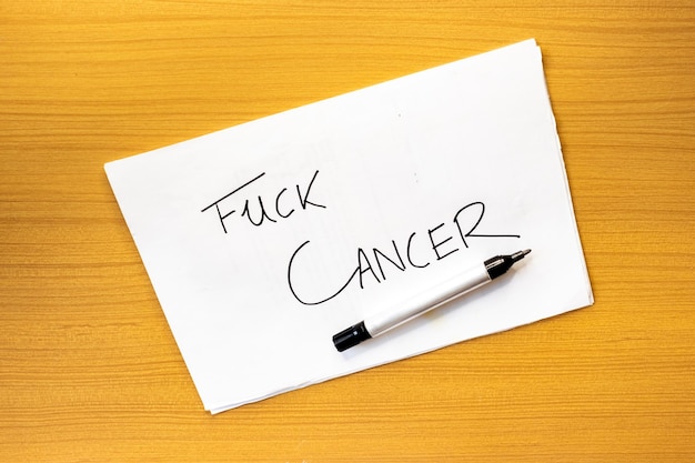 Scheda sul tavolo FUCK CANCER Messaggio su cartone contro il cancro Concetto di scrittura a mano su cartone FUCK CANCER