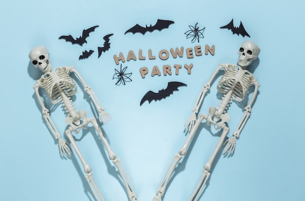 Scheletri e pipistrelli, ragni su sfondo blu brillante con la parola festa di Halloween. Tema di Halloween.