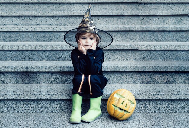 Scheletro di Halloween, il bambino si diverte all'aria aperta sui gradini ha un ragazzino felice a un p...