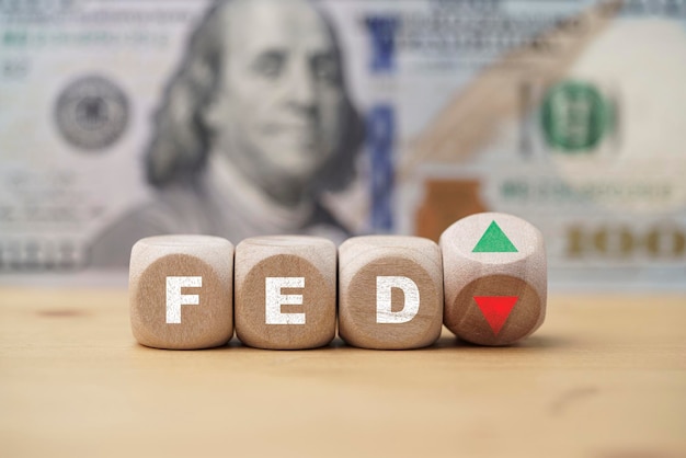 Schermata di stampa FED su blocco cubo di legno con freccia su e sfondo di banconote in dollari USA per il concetto di aumento e diminuzione del tasso di interesse