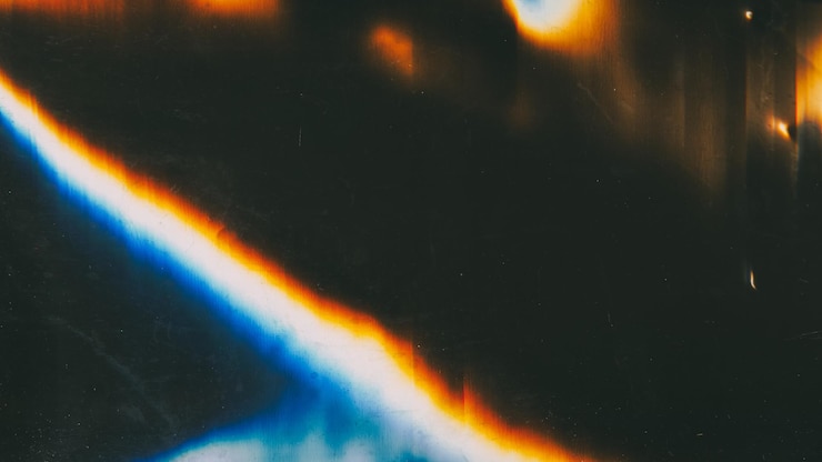 Foto schermata nera con rumore di distorsione dello sfondo sovrapposta con luce glitch e sbavature blu-arancio brillanti