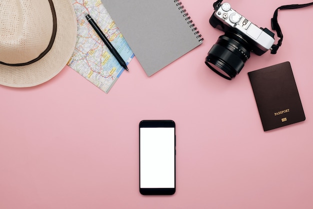 Schermo bianco dello Smart Phone, fondo di concetto del viaggiatore con il telefono e macchina fotografica su carta pastello.