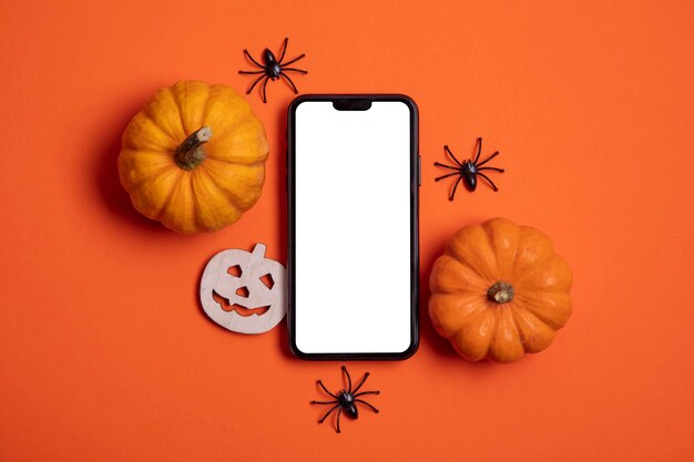 Schermo dello smartphone bianco vuoto con zucche e ragni