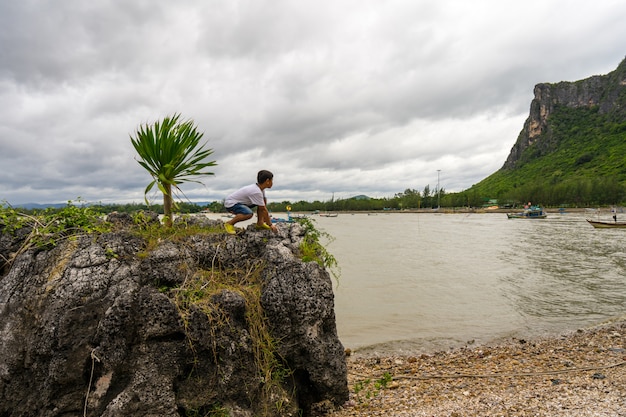 Scherzi il ragazzo che sta sulle rocce a Khao Ta Mong Lai Forest Park, Prachuap Khiri Khan.