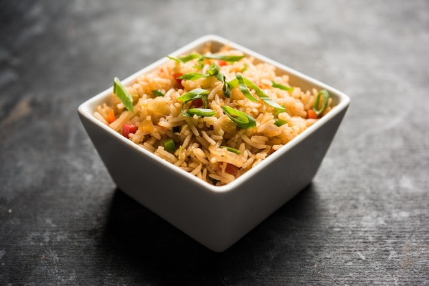 Schezwan Fried Rice Masala è un popolare cibo indo-cinese servito in un piatto o in una ciotola con le bacchette