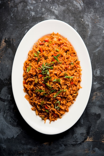 Schezwan Fried Rice Masala è un popolare cibo indo-cinese servito in un piatto o in una ciotola con le bacchette