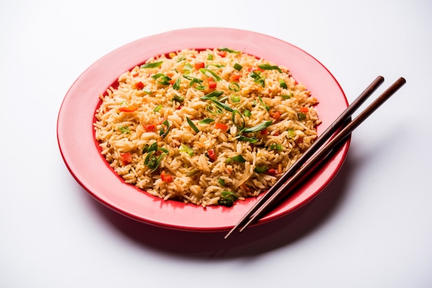 Schezwan Fried Rice Masala è un popolare cibo indo-cinese servito in un piatto o in una ciotola con le bacchette