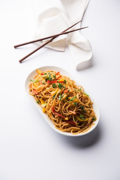 Schezwan Noodles o verdure Hakka Noodles o chow mein è una popolare ricetta indo-cinese, servita in una ciotola o in un piatto con bacchette di legno. messa a fuoco selettiva